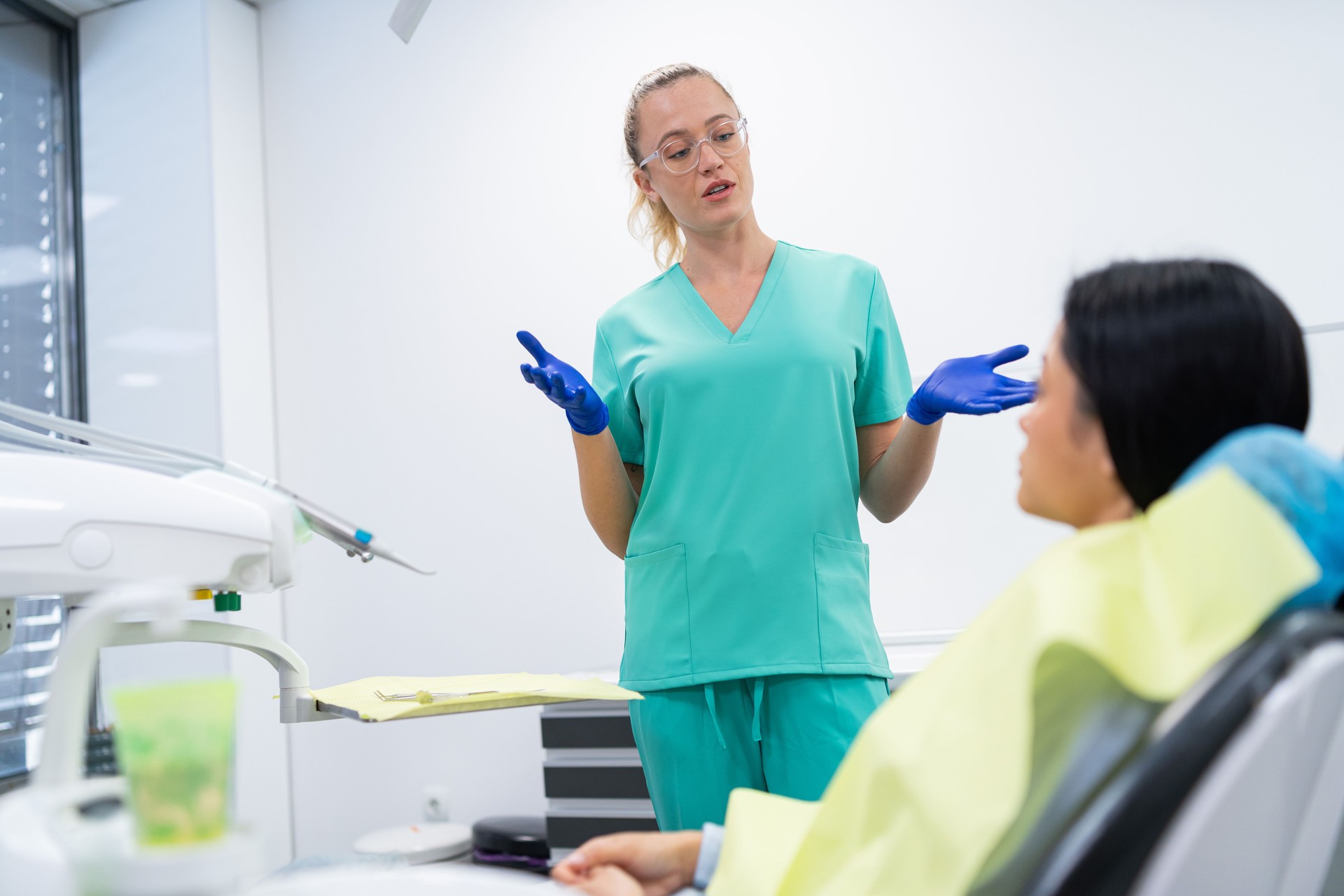 Female dentist giving some good news to her patient about the state of her dental health, while she's listening to her with a smile on her face