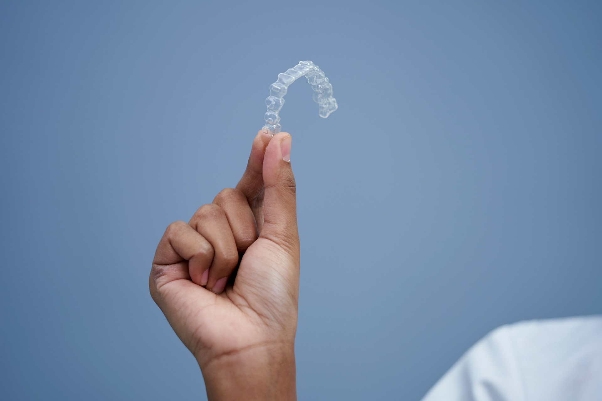 Close up of  dentist's hand  holding clear dental brace