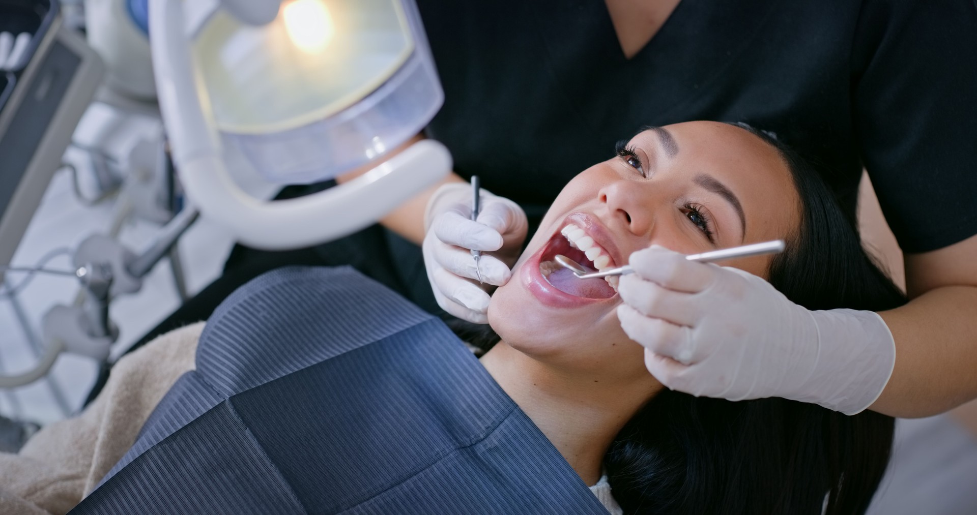 Dentist, woman and hands with mirror for teeth whitening, oral hygiene and consultation with gloves. Healthcare, specialist and patient for mouth wellness, dental service and check for gum bacteria