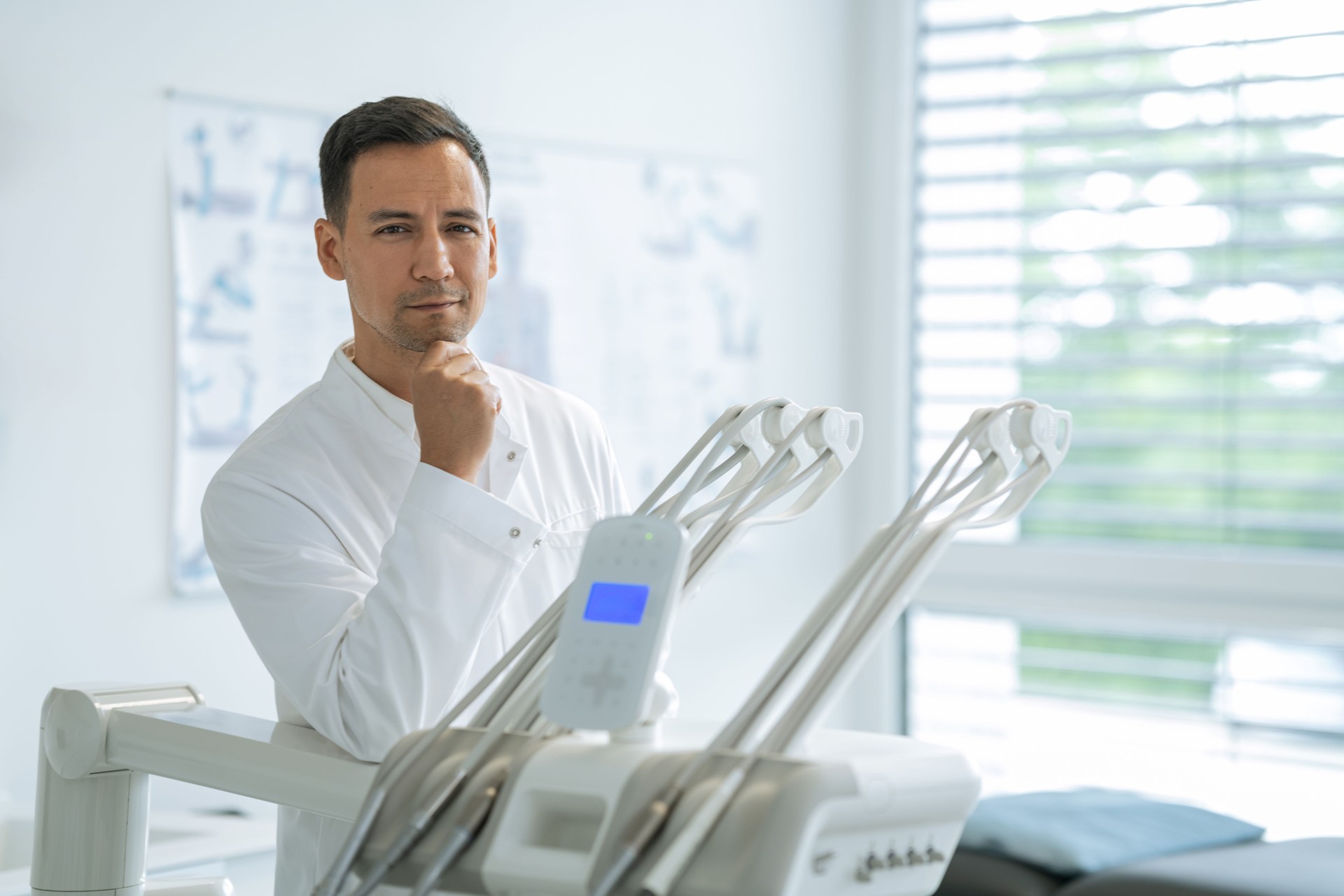 Portrait of confident a young dentist working in his consulting room