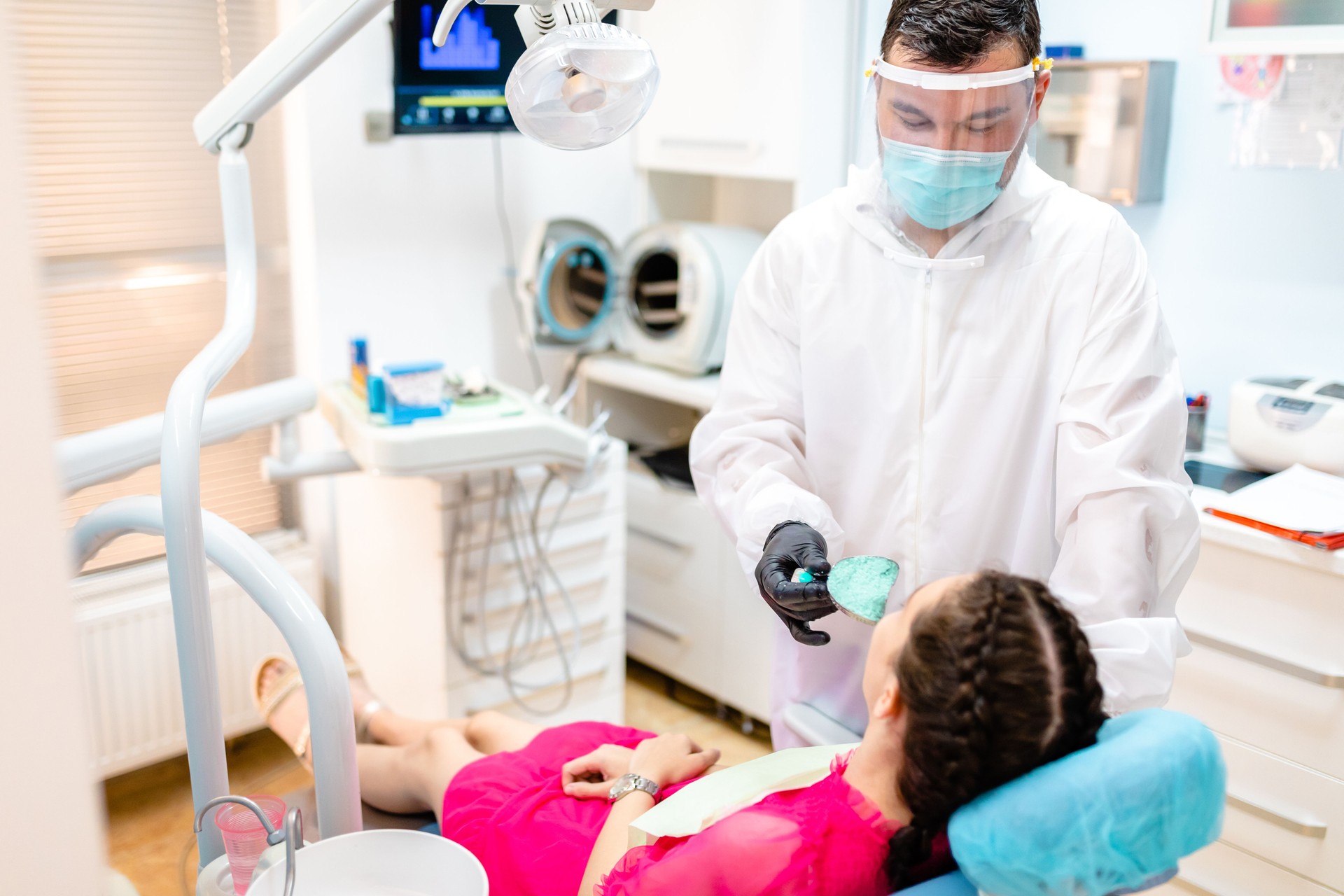 Dental prosthetist using a metal mold and silicon to take impression of patient teeth for dentures